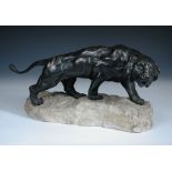 An Art Deco bronze model of a tiger, modelled stalking upon a carved alabaster base, signed "