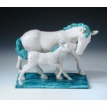 A Goldscheider model of a mare and foal, in white and turquoise crackle glaze, painted and impressed