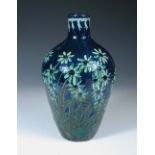 An earthenware vase by Professor Max Läuger, slip decorated with foliate design over deep blue