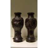 A pair of late 19th/early 20th century bronze vases, one of the baluster bodies cast in relief