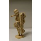 A late 19th/early 20th century ivory of a basket vendor, he walks with his wares on a shoulder pole,