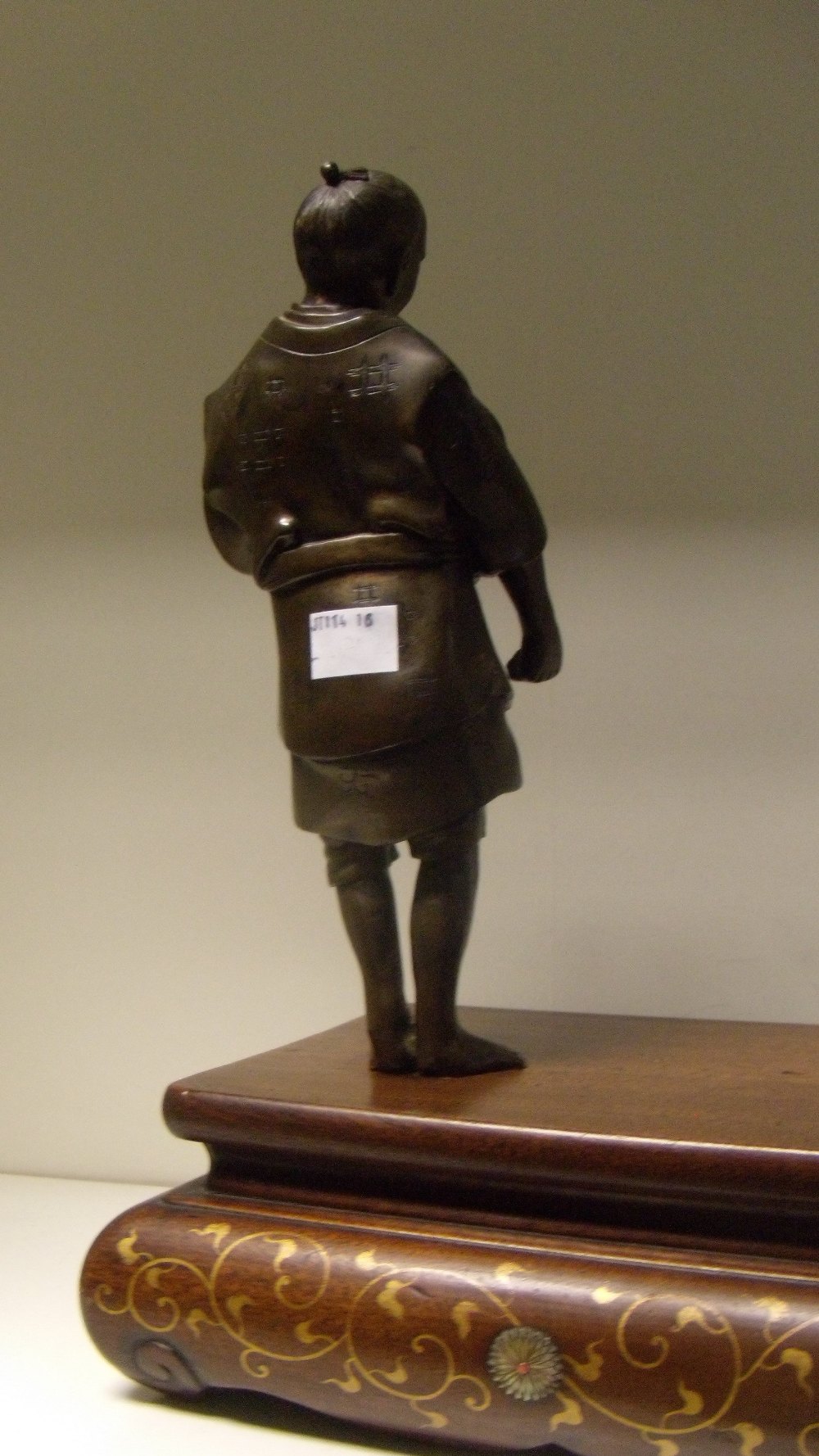 A late 19th/early 20th century bronze figure of a man standing to one corner of a wooden stand - Image 3 of 3