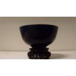 An aubergine glazed bowl incised with clouds alternating with floral rosettes on the exterior, a