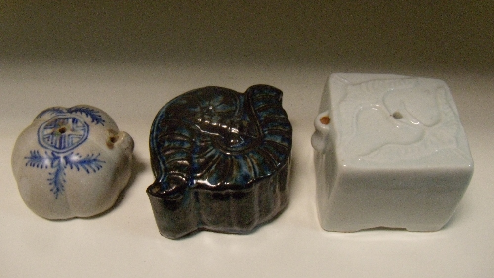 Three 19th century Korean water droppers, the square top of the white glazed example moulded with