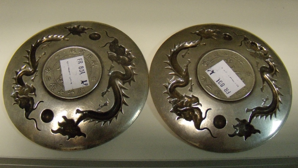 A pair of early 20th century silver coin inset dishes, the dishes cast and chased with two dragons - Image 2 of 2