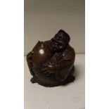 A 20th century bronze figure of Ebisu seated laughing as he holds a giant carp before him, the