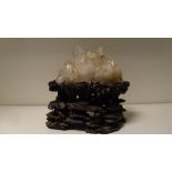 A quartz crystal on a carved hard wood stand, the naturally formed crystal on a stand carved with