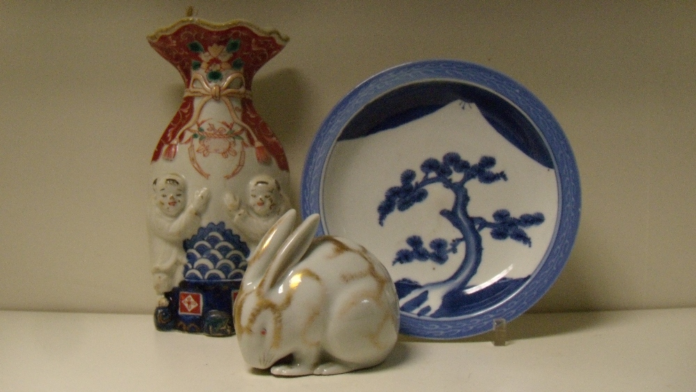 An Arita blue and white plate, a Kutani rabbit and and Imari wall pocket, the plate painted with a