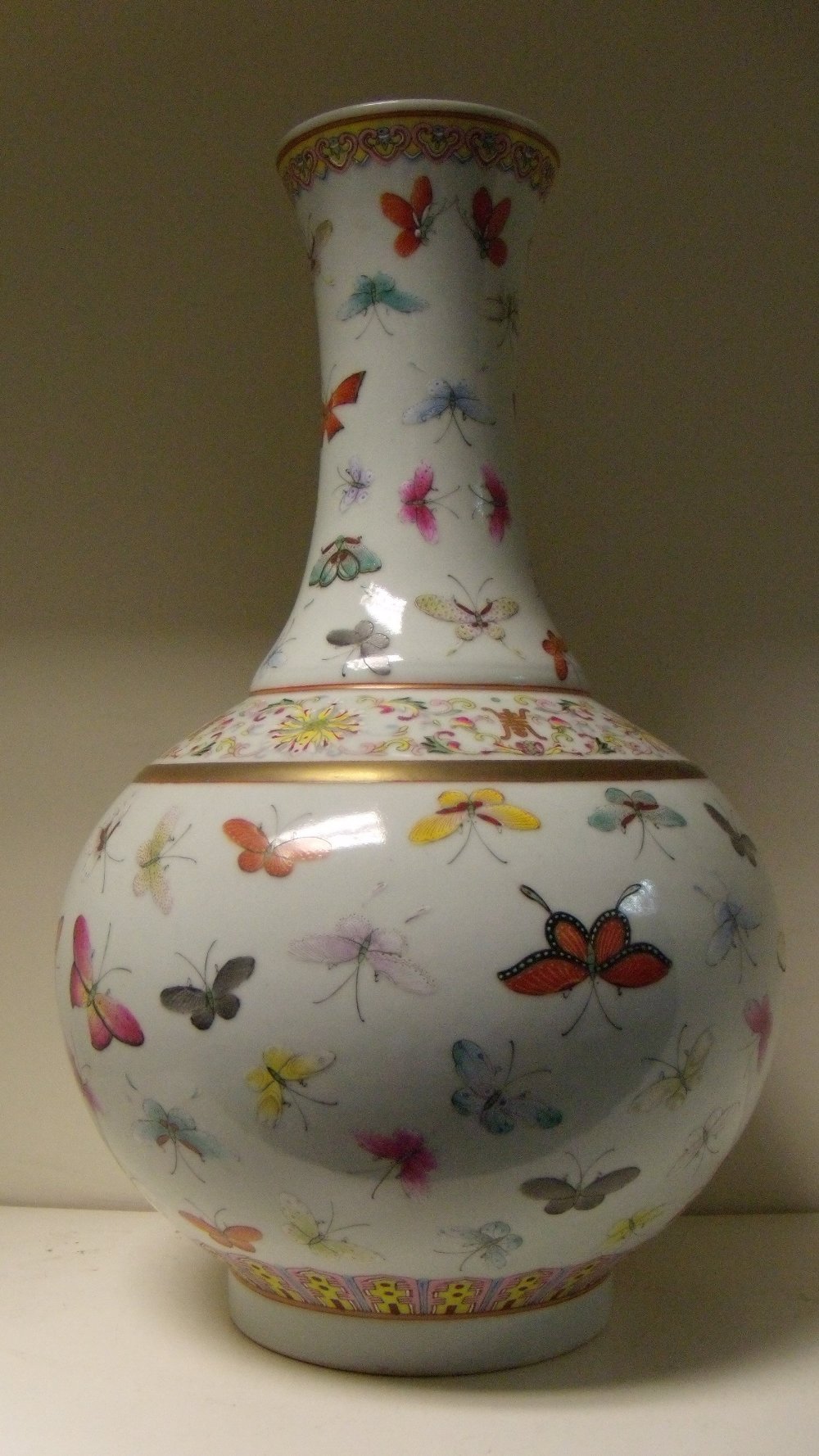 A 19th century famille rose bottle vase, six character mark of Guangxu, ruyi lappets in a band on