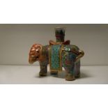 A 19th century Canton elephant candlestick, the pachyderm with orange head and floral stippled