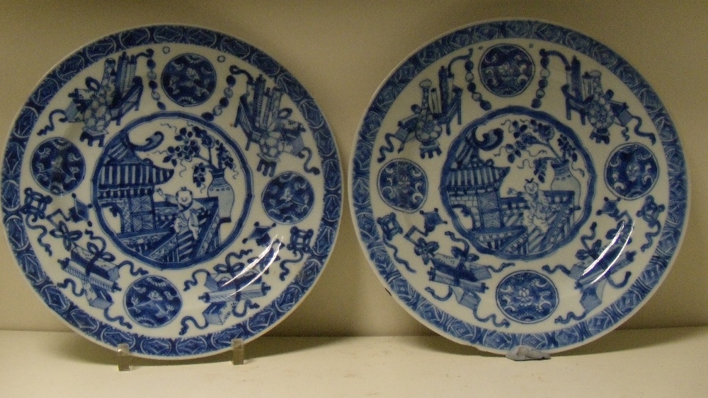 A pair of blue and white plates, period of Kangxi, each centrally painted with a boy waving from a