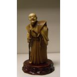 An early 20th century ivory figure of a samurai, the grey haired man wears a daisho with his