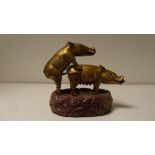 Two gilt bronze pigs, the sow standing four square as the boar penetrates her, their tusks white and
