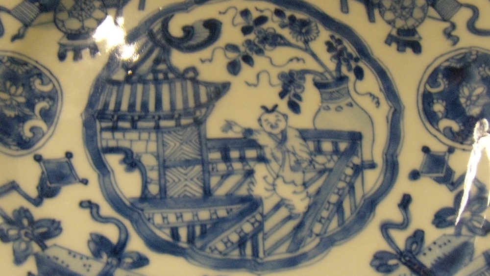 A pair of blue and white plates, period of Kangxi, each centrally painted with a boy waving from a - Image 2 of 3