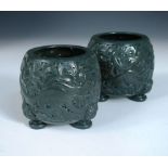 A pair of spinach green jade vases, the barrel shaped sides pierced and carved with a tangle of