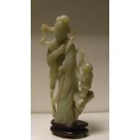 A 19th/20th century nephrite figure of a lady standing, one end of her windswept scarf held by a boy