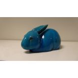 A 19th century turquoise glazed figure of a rabbit. the black eyed animal reclining with its ears