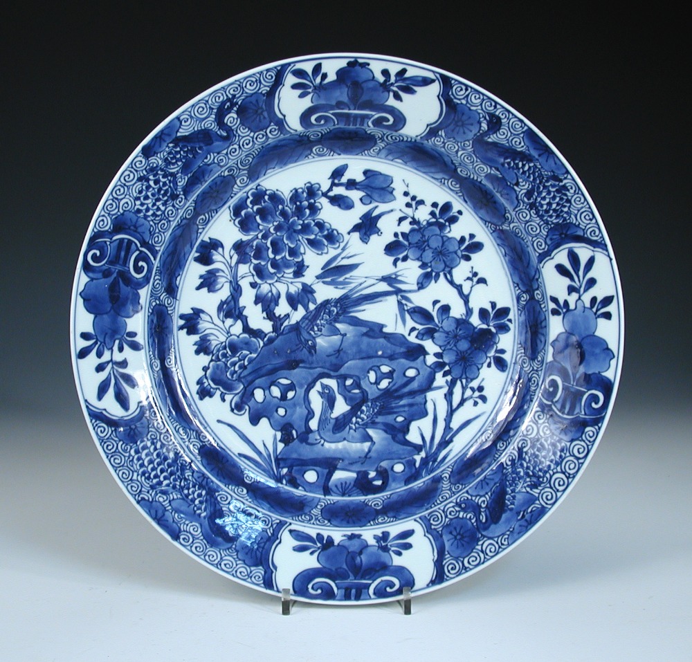 A blue and white dish, period of Kangxi, centrally painted with birds about a rock amongst peonies