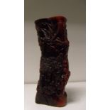 A red stained horn brush pot, the exterior carved in relief with sages in a mountain retreat amongst