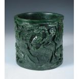 A spinach green jade brush pot, the exterior of the cylindrical shape carved in deep relief with two