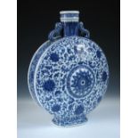 A Ming style blue and white moon flask. scroll handles joining the shoulders to the stiff leaf