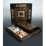 A mid 19th century black lacquer games box, gilt floral panels and grape vine bands enclosing the