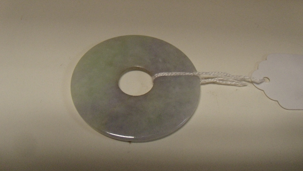 A jadeite bi, the mauve and green mottled white disc slightly rounded between the central hole and