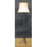 An adjustable wrought iron standard lamp on tripod base, and a Victorian scroll leg footstool (2)