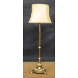 An Edwardian brass telescopic standard lamp on circular base with three feet