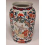 An Oriental imari vase decorated with figures in flowering panels, 26cm high