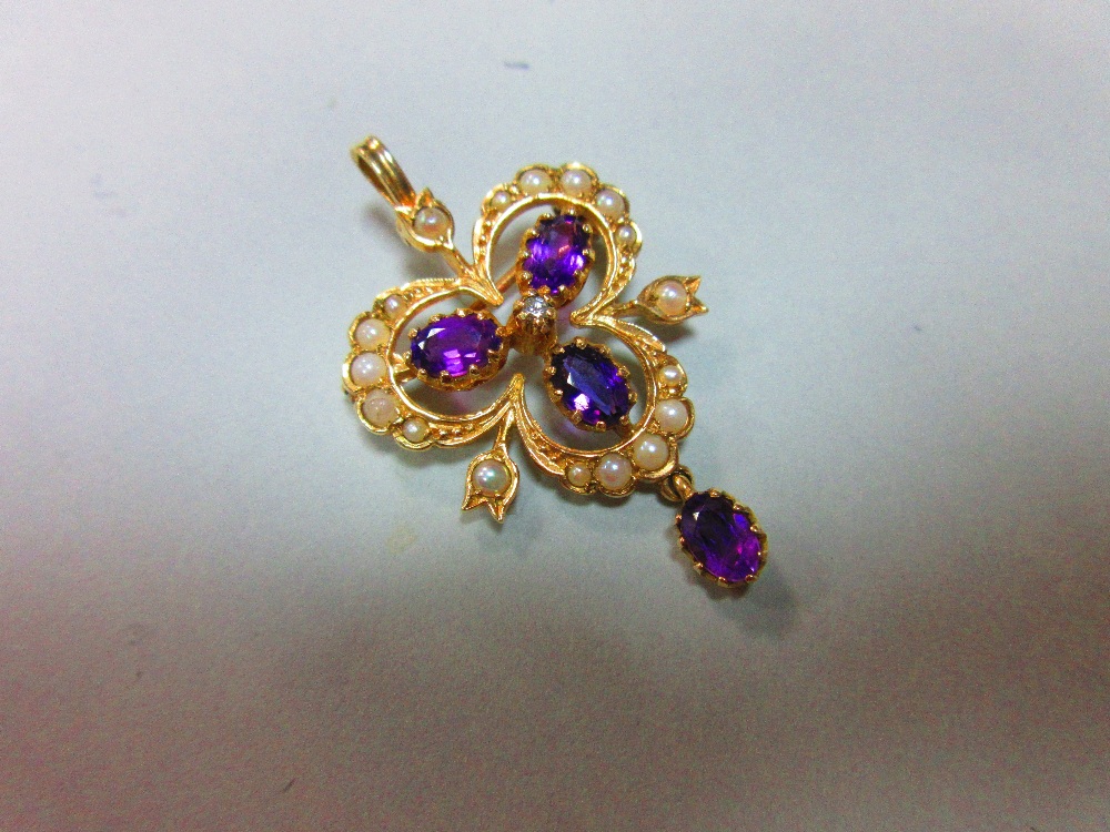 A gold, amethyst, seed pearl and diamond pendant / brooch, designed as an open trefoil delineated