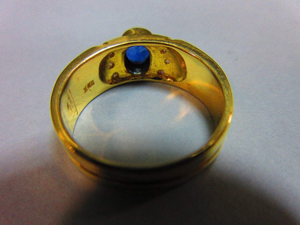 A sapphire and diamond ring, the oval cut intense blue sapphire in a raised collet between lines - Image 3 of 4