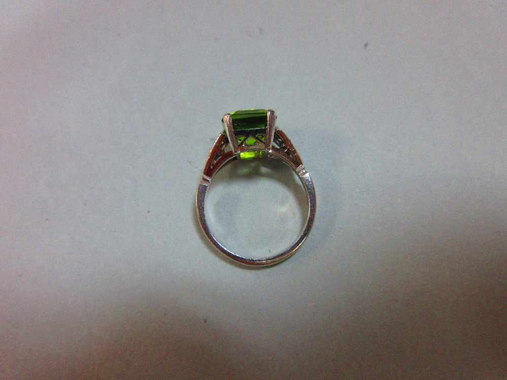 A 1930s style peridot and diamond ring, the emerald cut peridot measuring 10.6 x 8.7mm, four claw - Image 3 of 5