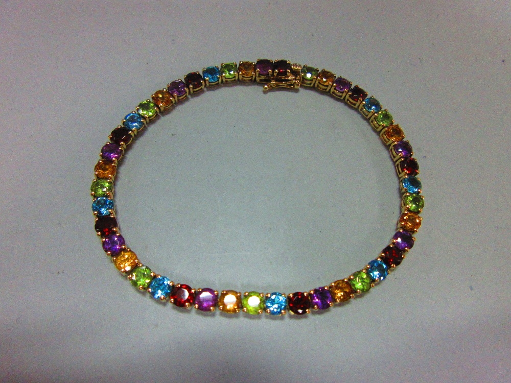 A multi-coloured gem set line bracelet, the uniform round cut gems, to include garnet, blue topaz,