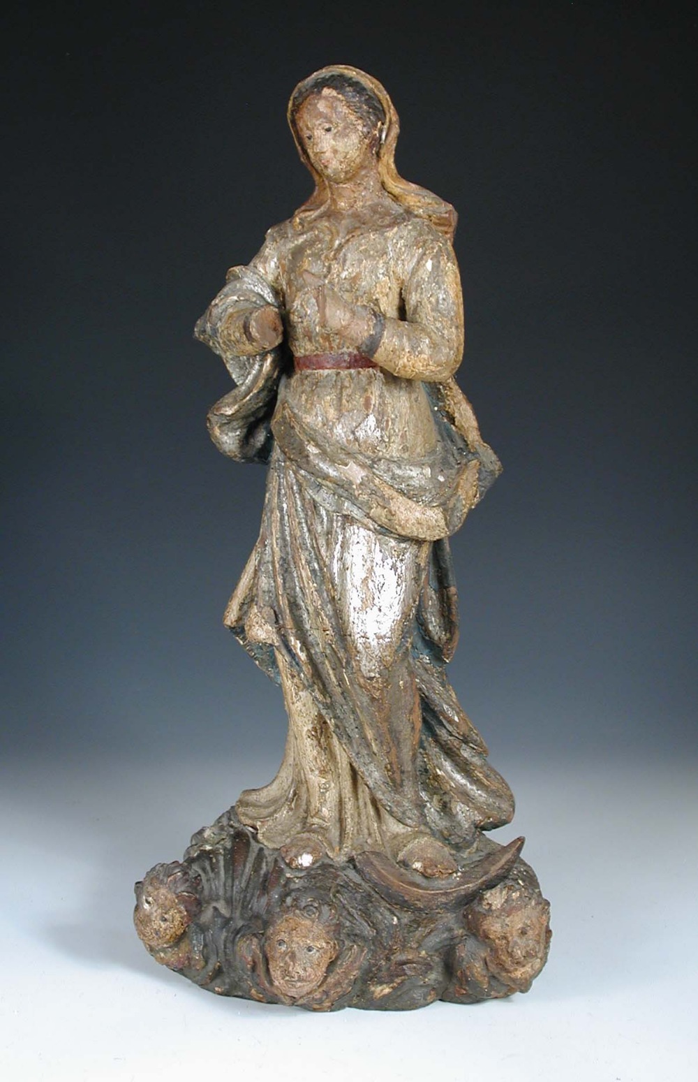 An 18th century carved wood polychrome figure of the Madonna, possibly Spanish, she wears a blue