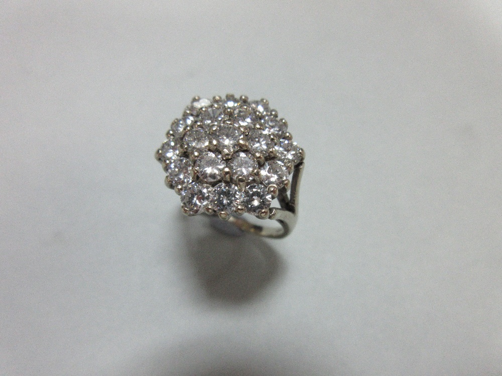 A diamond cluster ring set in 18ct gold, closely set with nineteen round brilliant cut diamonds in a