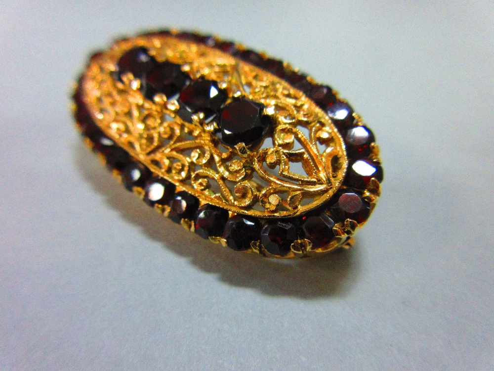 An Italian 18ct gold and garnet brooch, of elongated oval outline delineated by round cut deep red - Image 4 of 4