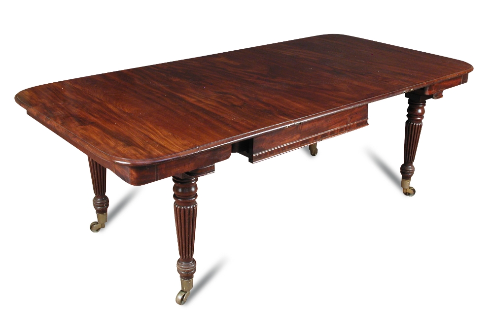 A William IV mahogany extending dining table, in the manner of Gillow, with drop leaf ends, one