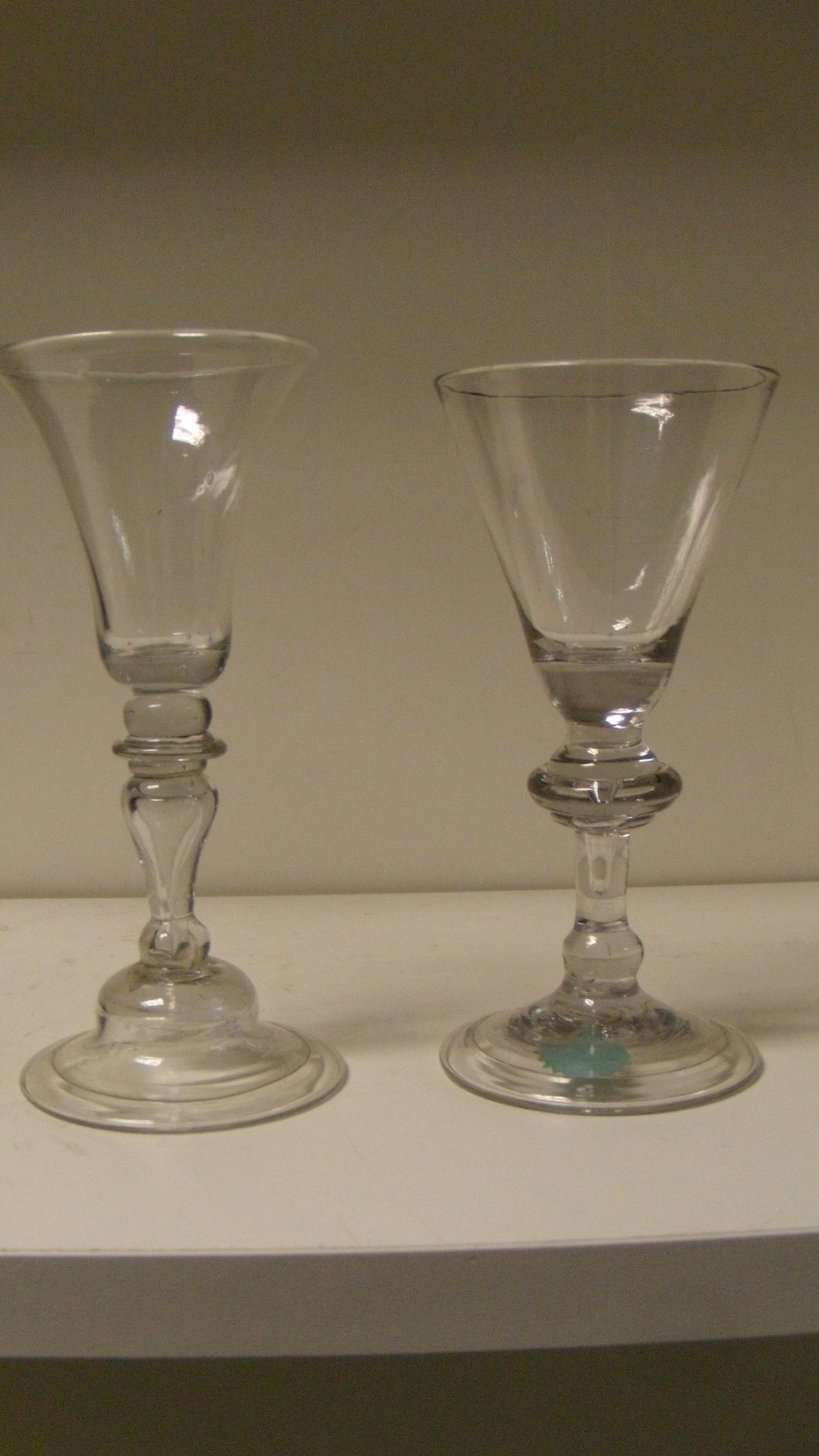 Two 18th century European wine glasses, each with hollow stems and on folded feet, one with bell