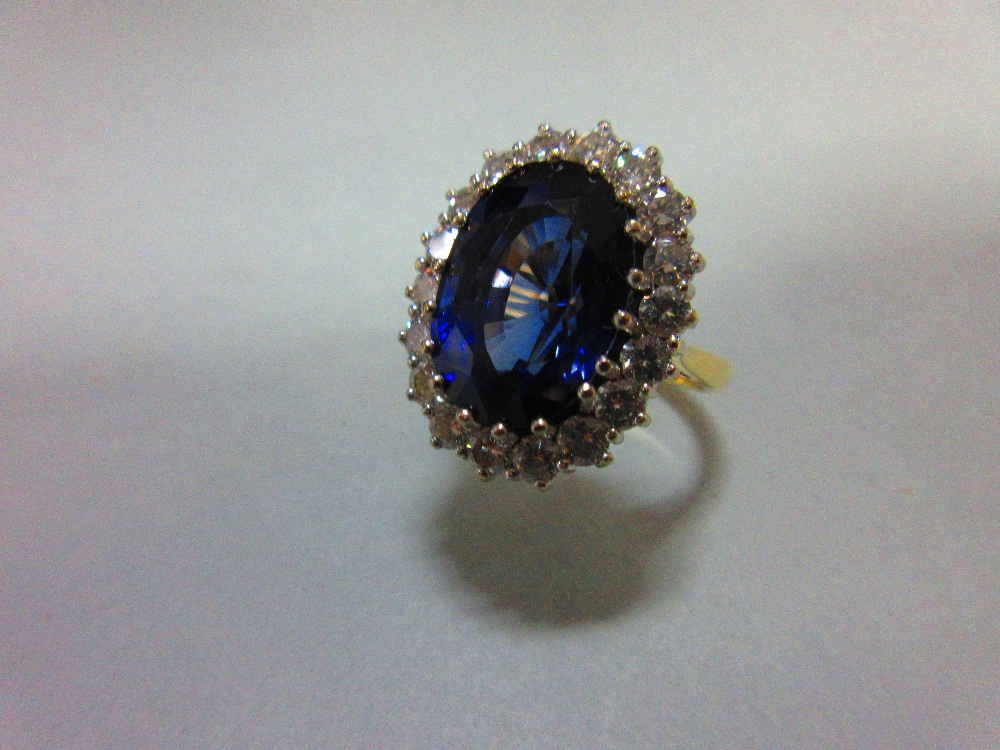 A large sapphire and diamond cluster ring, the oval cut deep blue sapphire, estimated weight 9. - Image 2 of 6