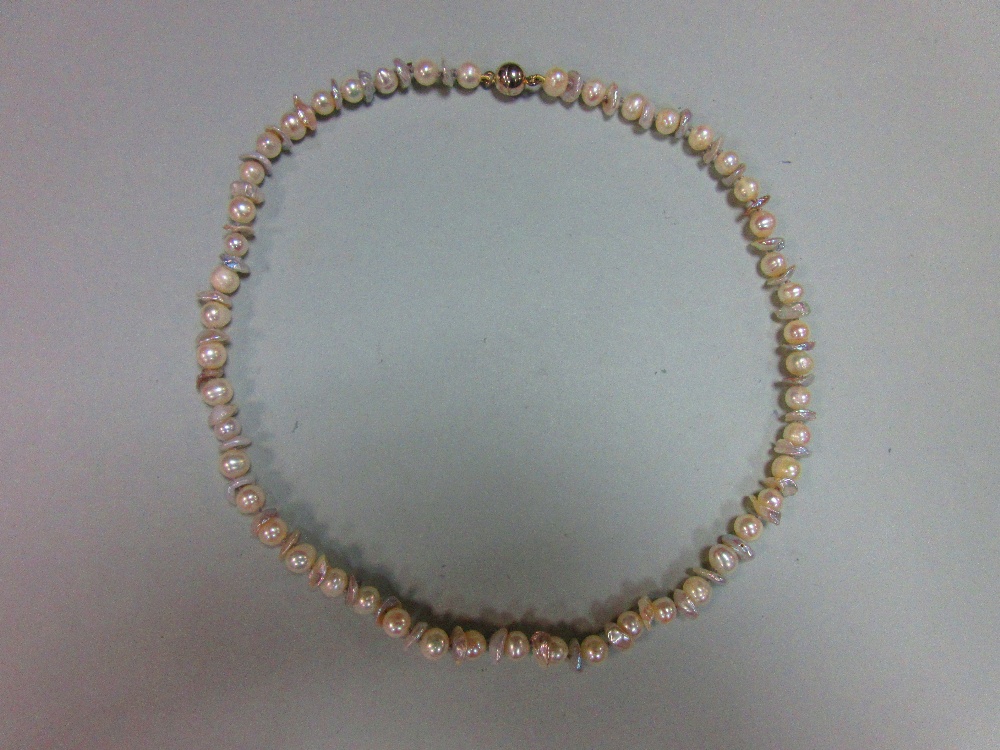 A contemporary pearl necklace, composed of oval white pearls alternating with pale dove grey flake