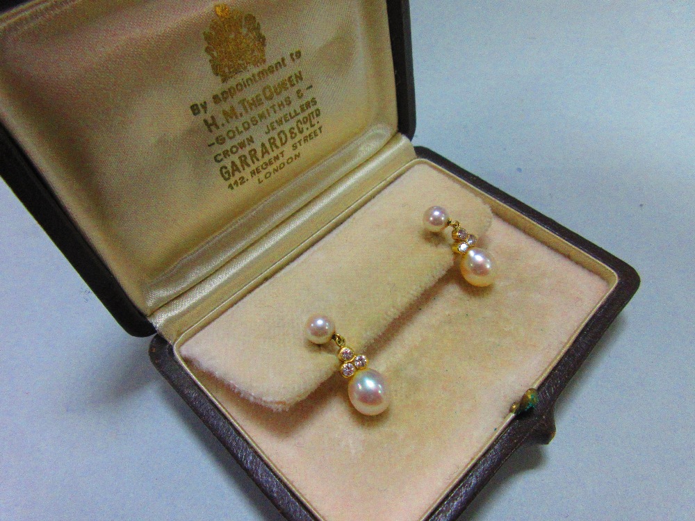 A pair of pearl and diamond earpendants cased by Garrard, each post headed by a 5mm pearl and