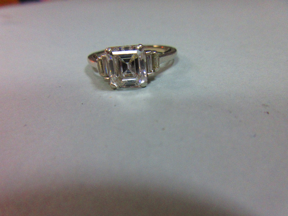 A diamond ring, the emerald cut principal stone, estimated weight 2.04cts, with two stepped baguette - Image 6 of 6