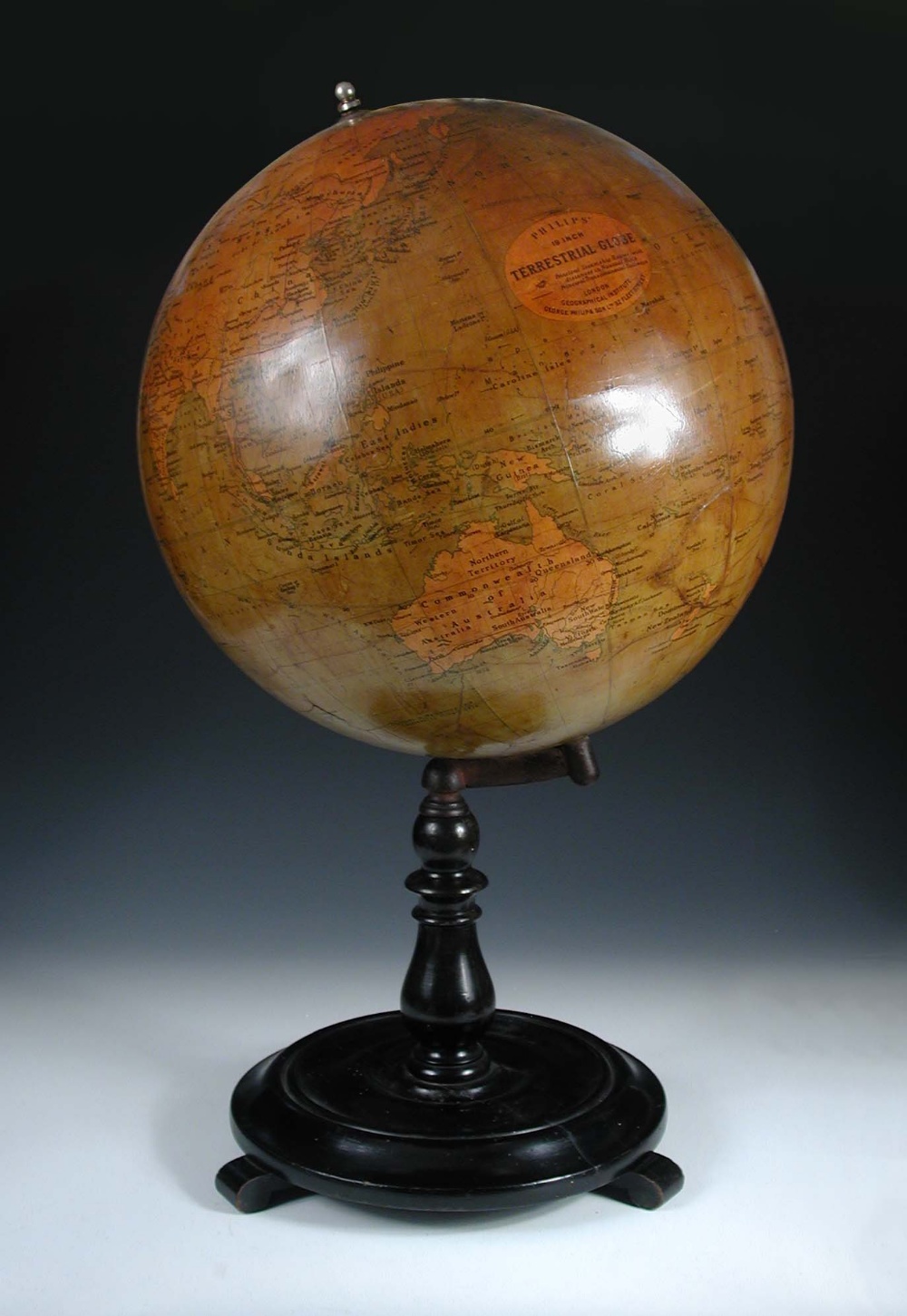 A Philips' 19 inch terrestial globe, with dark varnished gores, on an ebonised turned wood stand