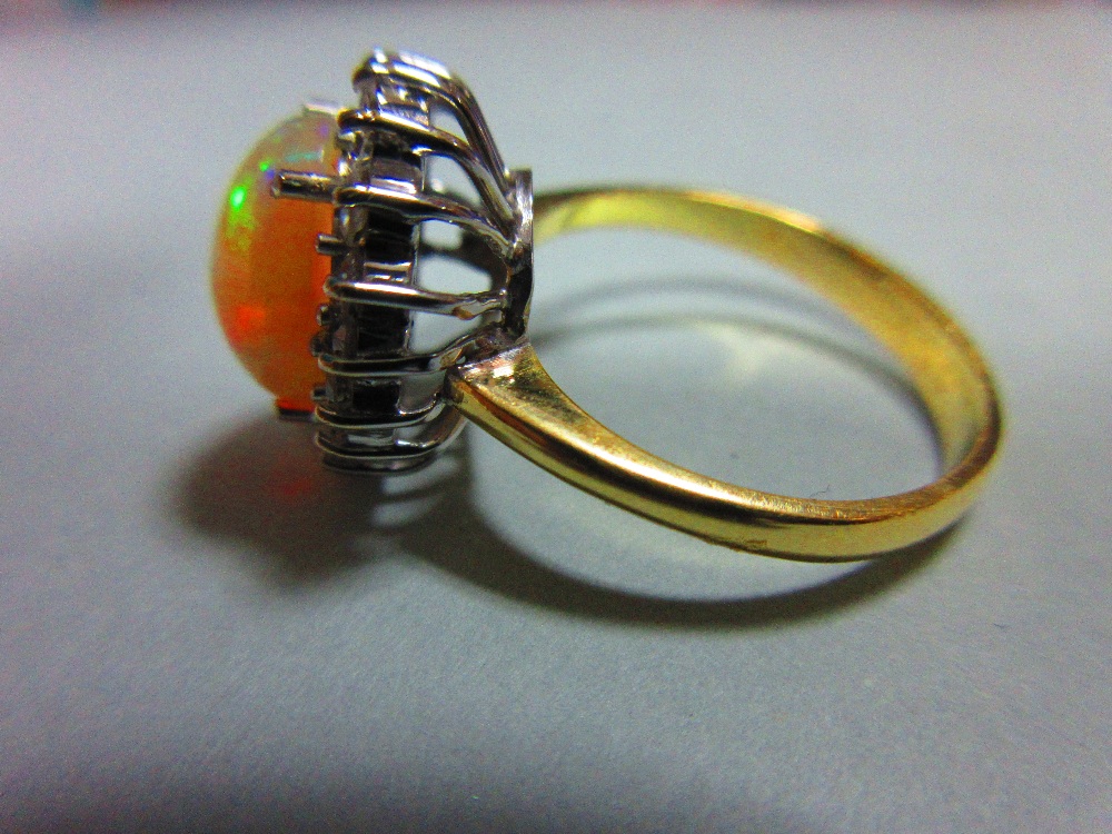 An opal and diamond cluster ring, the oval cabochon opal, displaying vivid predominently green and - Image 4 of 6