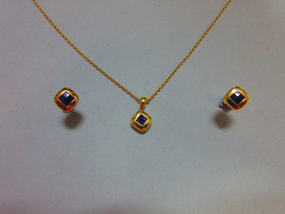 A mystery set sapphire and 18ct gold suite of pendant and earstuds by Wempe, the pendant and each