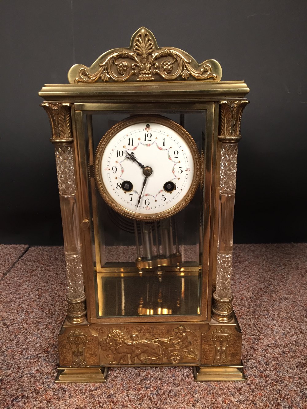 A French gilt brass four-glass mantle clock, with swagged enamel 8cm (3in) dial, glass front