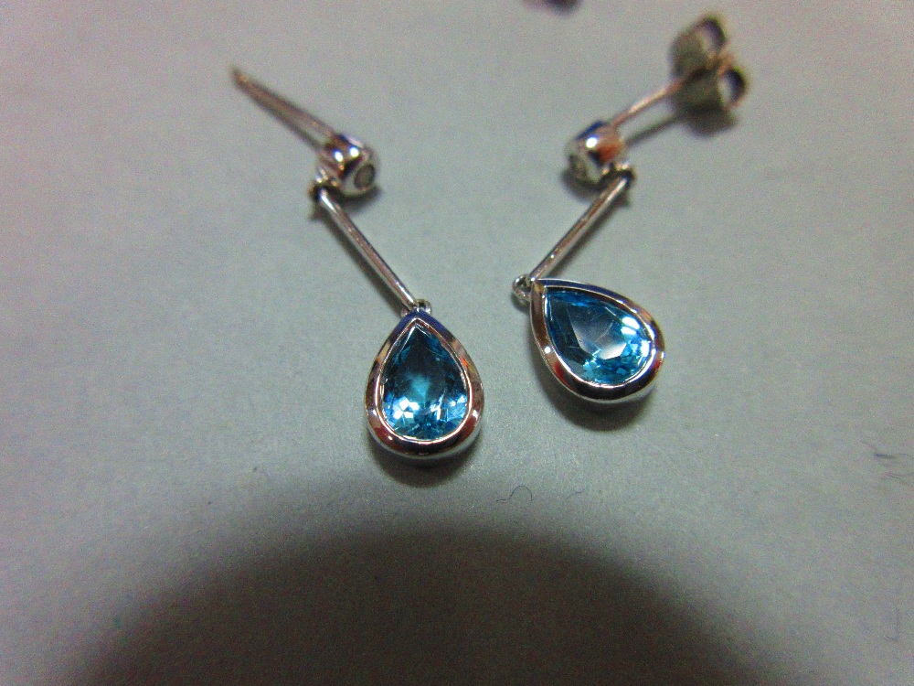 A pair of blue topaz, diamond and white gold earpendants, each post headed by a collet set round - Image 3 of 3