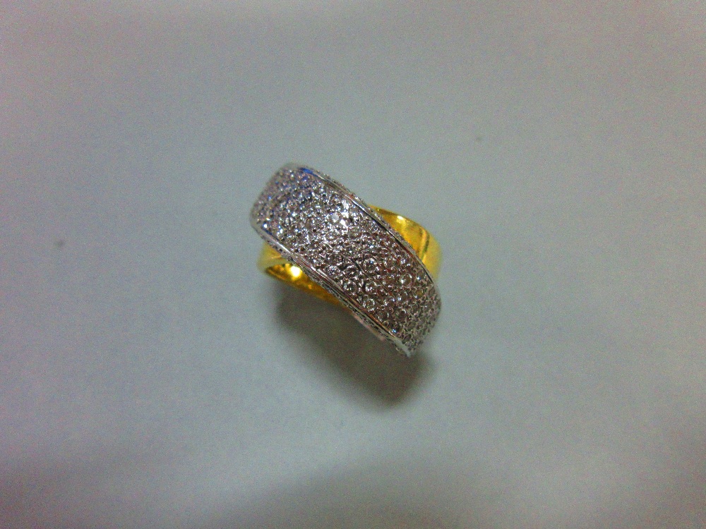 A modern diamond crossover band ring, of precious metal stamped '750' and designed as a plain