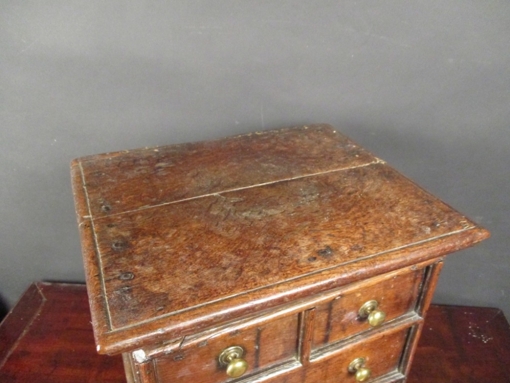 A small 17th century oak chest, a hinged top with false drawer fronts and brass handles, on later - Image 2 of 5